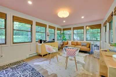 a living room with a couch and a table at Sweetfern Gouldsboro Cabin Deck and Lake Access in Gouldsboro