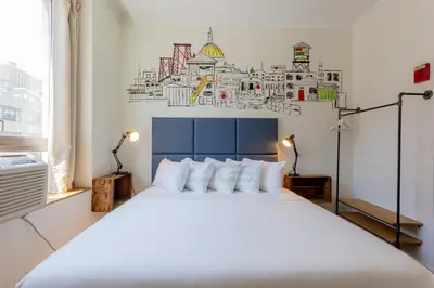a bedroom with a large white bed in a room at JG Sohotel in New York