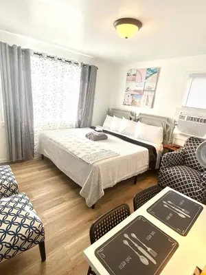 a bedroom with two beds and a table and chairs at Cobmin Ridge Motel in Branchville