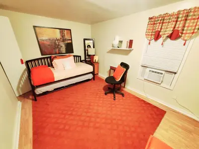 a bedroom with a bed and a chair and a window at Fall Room 3min From Yale, And Other Colleges in New Haven