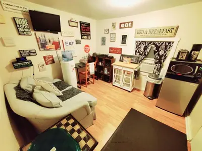 a room with two beds and a kitchen with a refrigerator at Fall Room 3min From Yale, And Other Colleges in New Haven