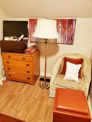 a living room with a chair and a lamp and a dresser at Fall Room 3min From Yale, And Other Colleges in New Haven