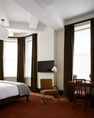a bedroom with a bed and a desk and a chair at Nine Orchard in New York