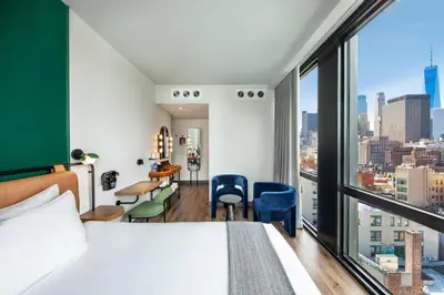 a hotel room with a bed and a large window at Moxy NYC Lower East Side in New York
