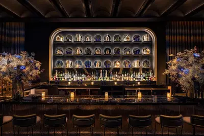 a bar in a restaurant with a wall of vases at Moxy NYC Lower East Side in New York