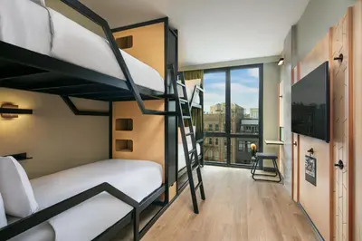 a room with two bunk beds and a balcony at Moxy Brooklyn Williamsburg in Brooklyn