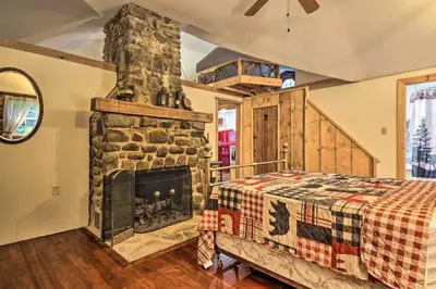 a bedroom with a stone fireplace and a bed at Cabin with Trails and Creek! 23 Mi to Camelback Slopes in Greentown