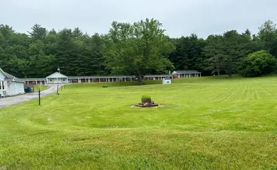a large green field with a tree in the middle at Starlight Inn in Bennington