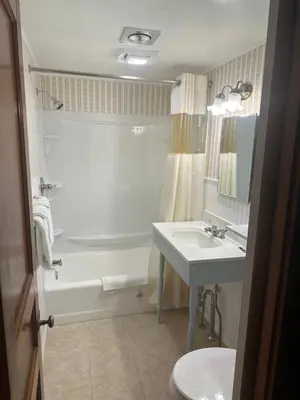 a bathroom with a tub and a sink and a toilet at Starlight Inn in Bennington