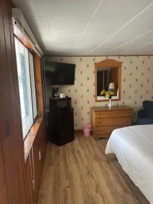 a bedroom with a bed and a flat screen tv at Starlight Inn in Bennington