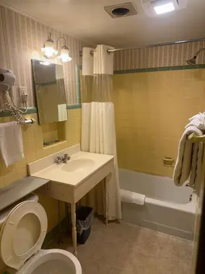 a bathroom with a sink and a toilet and a tub at Starlight Inn in Bennington