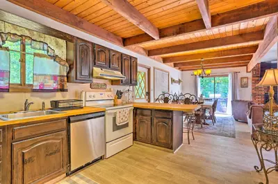 a kitchen with wooden cabinets and a dining room at Bushkill House with Deck and Community Amenities! in Bushkill
