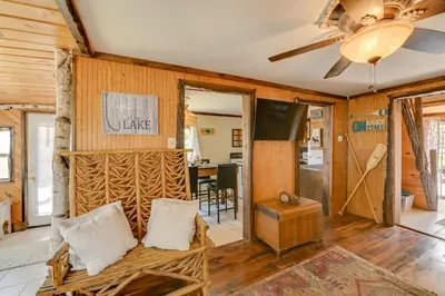 a living room with wooden walls and a couch at Rustic Caroga Lake Retreat Fish, Hike and Ski! in Caroga Lake