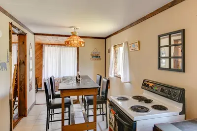 a kitchen and dining room with a stove and a table at Rustic Caroga Lake Retreat Fish, Hike and Ski! in Caroga Lake