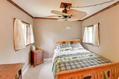 a bedroom with a bed and a ceiling fan at Rustic Caroga Lake Retreat Fish, Hike and Ski! in Caroga Lake