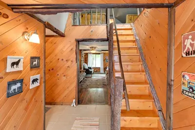 a staircase in a cabin with wood walls at Rustic Caroga Lake Retreat Fish, Hike and Ski! in Caroga Lake