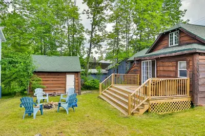 a cabin with a deck and chairs in the yard at Rustic Caroga Lake Retreat Fish, Hike and Ski! in Caroga Lake