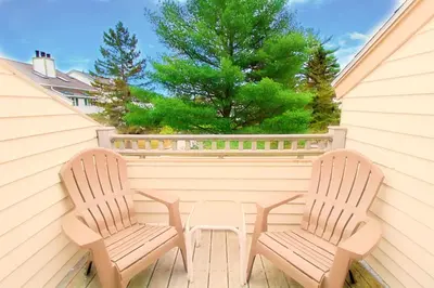 two chairs and a table on a porch at The Ponds at Foxhollow in Lenox