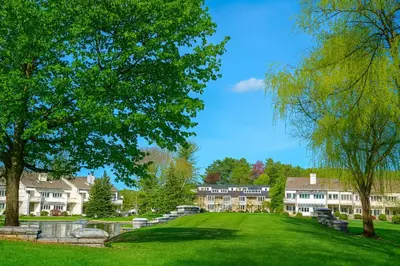 a view of a campus with trees and buildings at The Ponds at Foxhollow in Lenox