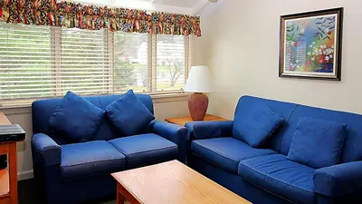 a living room with two blue couches and a table at The Ponds at Foxhollow in Lenox