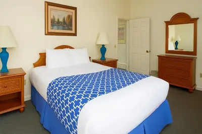 a bedroom with a blue and white bed and a mirror at The Ponds at Foxhollow in Lenox