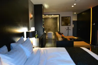 a bedroom with a bed and a living room at The One Boutique Hotel in Queens