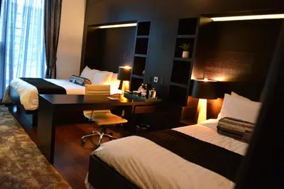 a hotel room with two beds and a desk at The One Boutique Hotel in Queens