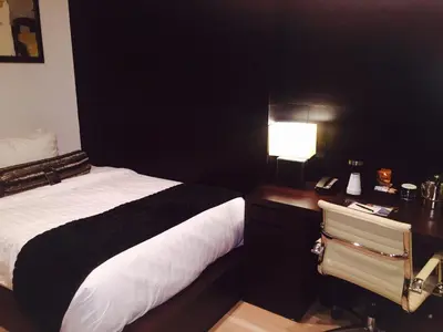 a bedroom with a bed and a desk with a lamp at The One Boutique Hotel in Queens