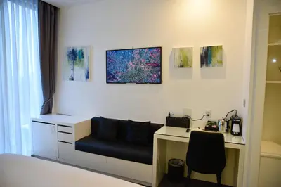 a bedroom with a desk and a bed and a desk with a chair at The One Boutique Hotel in Queens
