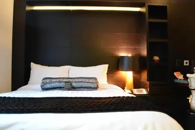 a bedroom with a large bed with a black headboard at The One Boutique Hotel in Queens