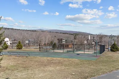 a park with two benches and a basketball court at Ski In Ski Out Cabin on Hunter Mtn Seasonal Pool Access w Panoramic Views Hike Swim Fish Relax in Lanesville