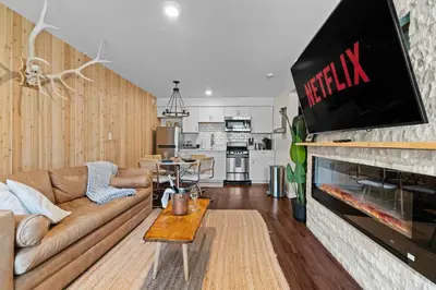 a living room with a couch and a tv on a fireplace at Ski In Ski Out Cabin on Hunter Mtn Seasonal Pool Access w Panoramic Views Hike Swim Fish Relax in Lanesville