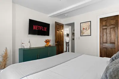 a bedroom with a white bed and a green cabinet at Ski In Ski Out Cabin on Hunter Mtn Seasonal Pool Access w Panoramic Views Hike Swim Fish Relax in Lanesville