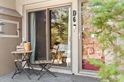 a porch with a table and a chair next to a door at Ski In Ski Out Cabin on Hunter Mtn Seasonal Pool Access w Panoramic Views Hike Swim Fish Relax in Lanesville