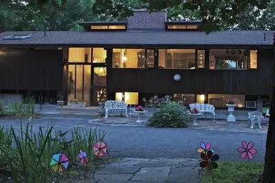 a large building with chairs and flowers in front of it at The Cottage in Stockbridge
