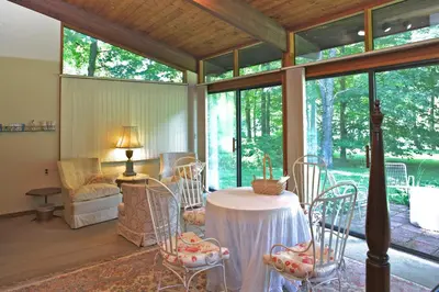 a living room with a table and chairs and windows at The Cottage in Stockbridge