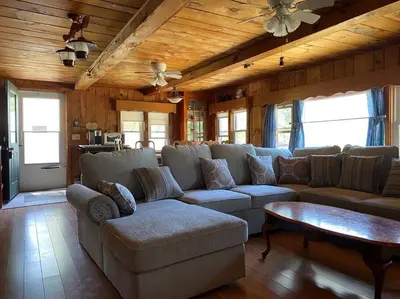 a living room with a couch and a table at Adirondack Waterfront Cabin Upper Hudson Tributary in Lake Luzerne