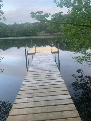 a wooden dock in the middle of a lake at Adirondack Waterfront Cabin Upper Hudson Tributary in Lake Luzerne
