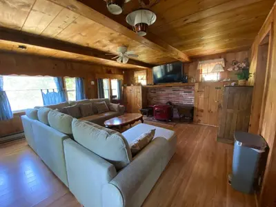 a living room with a couch and a table at Adirondack Waterfront Cabin Upper Hudson Tributary in Lake Luzerne