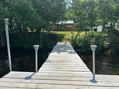 a wooden dock with two lights on the water at Adirondack Waterfront Cabin Upper Hudson Tributary in Lake Luzerne