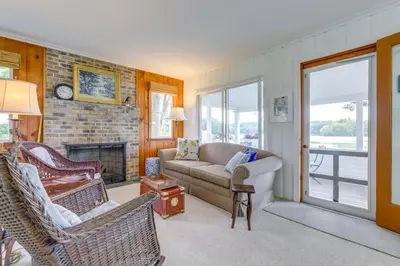 a living room with a couch and chairs and a fireplace at Lakefront Cottage with Covered Porch and Dock! in Coventry