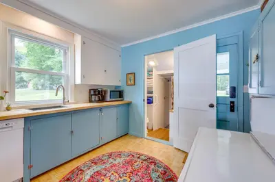 a kitchen with blue cabinets and a window at Lakefront Cottage with Covered Porch and Dock! in Coventry
