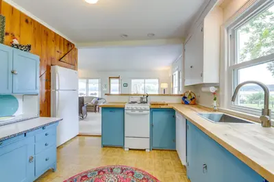 a kitchen with blue cabinets and a sink at Lakefront Cottage with Covered Porch and Dock! in Coventry