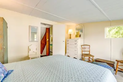 a bedroom with a bed and a dresser and a mirror at Lakefront Cottage with Covered Porch and Dock! in Coventry