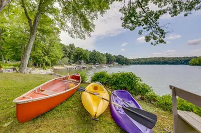 three boats sitting on the grass next to a lake at Lakefront Cottage with Covered Porch and Dock! in Coventry