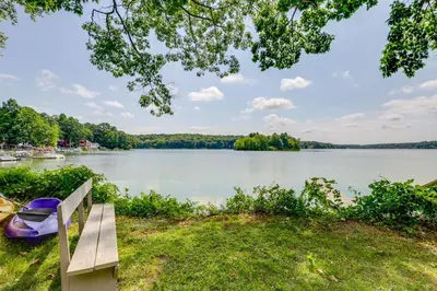 a park bench with a view of a lake at Lakefront Cottage with Covered Porch and Dock! in Coventry