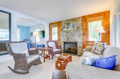 a living room with a couch and a fireplace at Lakefront Cottage with Covered Porch and Dock! in Coventry