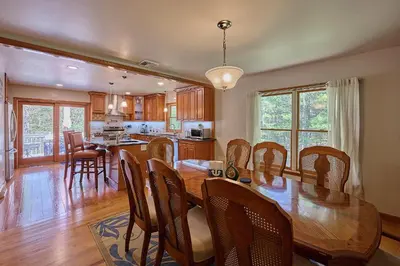 a kitchen and dining room with a wooden table and chairs at Spacious Catskills Serenity nearby Delaware River Gap w Game Rm Pet Friendly and Fenced Yard in Glen Spey
