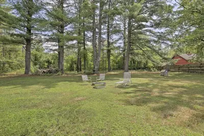 a group of chairs sitting in the grass in a field at Ashley Falls Home with Fire Pit Hike and Ski! in Ashley Falls
