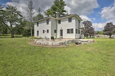 a large white house in a field of grass at Ashley Falls Home with Fire Pit Hike and Ski! in Ashley Falls